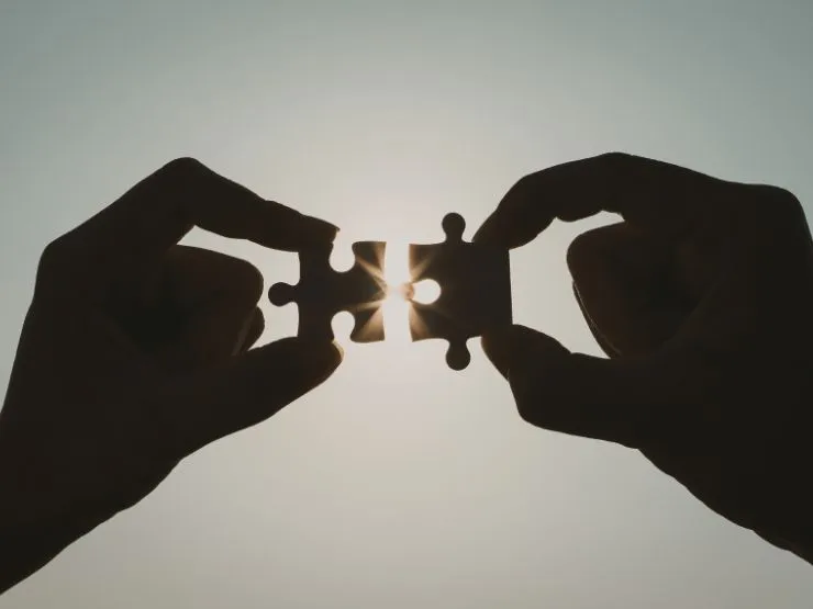 Instabilidade Familiar e Bloqueio Financeiro são representados na foto em que uma pessoa une duas peças de quebra-cabeças